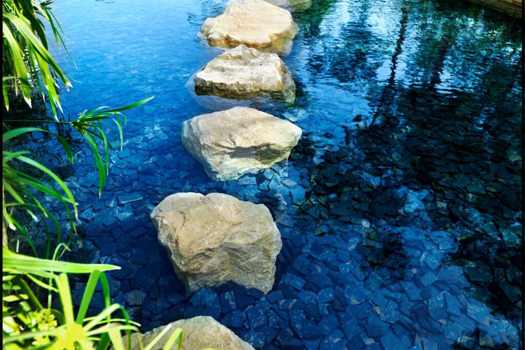 Series of stepping stones across clear blue water, symbolising a gentle journey and next steps.